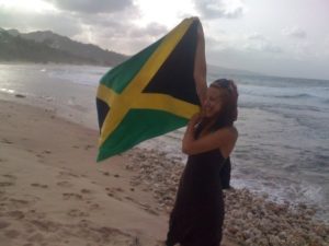 Julia Berge holding the Jamaican flag high on a trip in the Caribbean in 2009